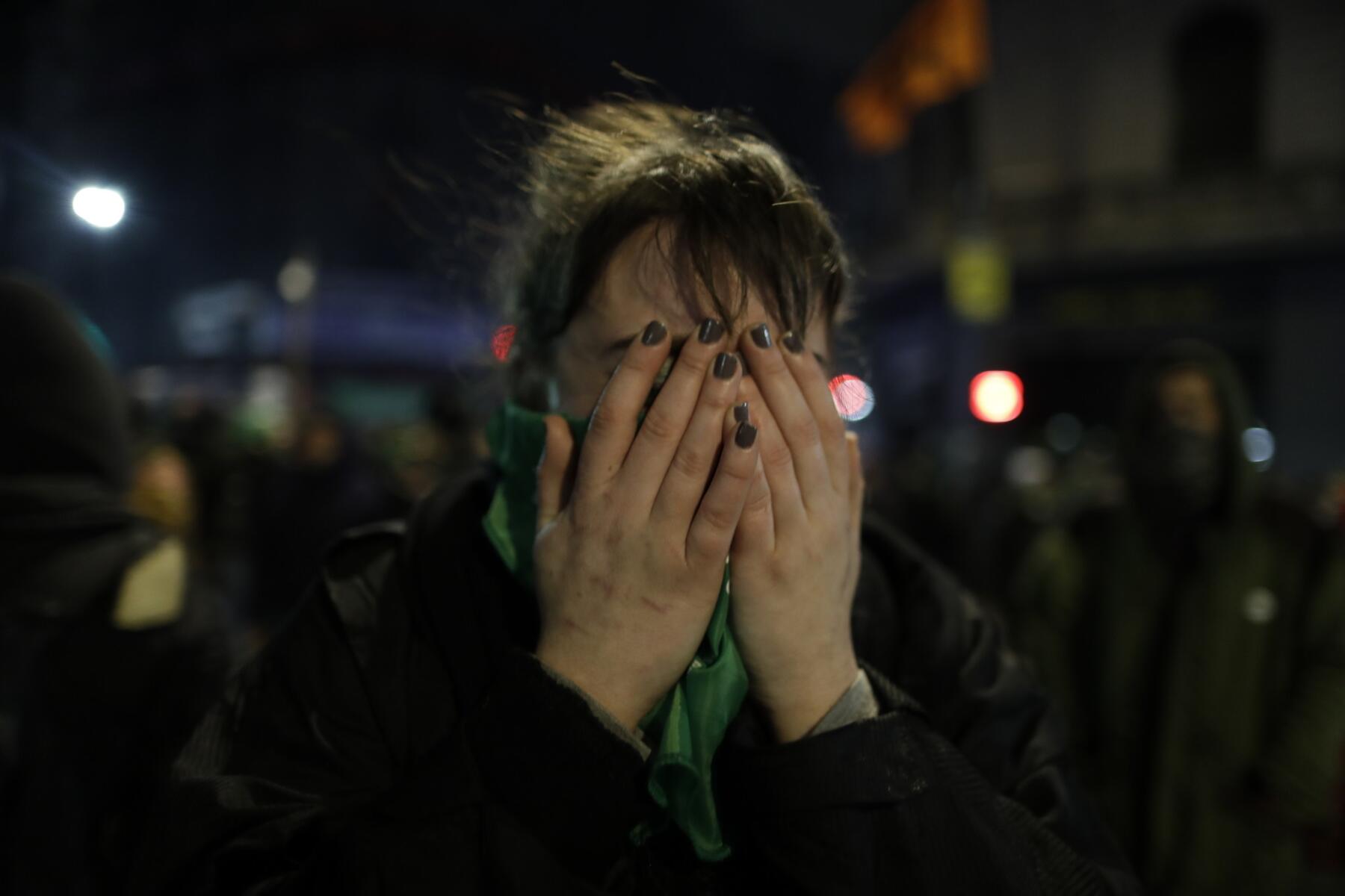 Una activista proaborto se tapa la cara con las manos luego de que el Senado rechazó una propuesta para legalizar el aborto antes de las 14 semanas, en el exterior del Congreso, en Buenos Aires, Argentina, el 9 de agosto de 2018. (AP Foto/Natacha Pisarenko)